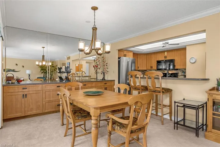 Dining area featuring a chandelier, crown molding, light colored carpet, and ceiling fan