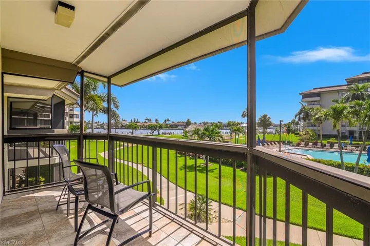 Balcony with view of pool area and a water view
