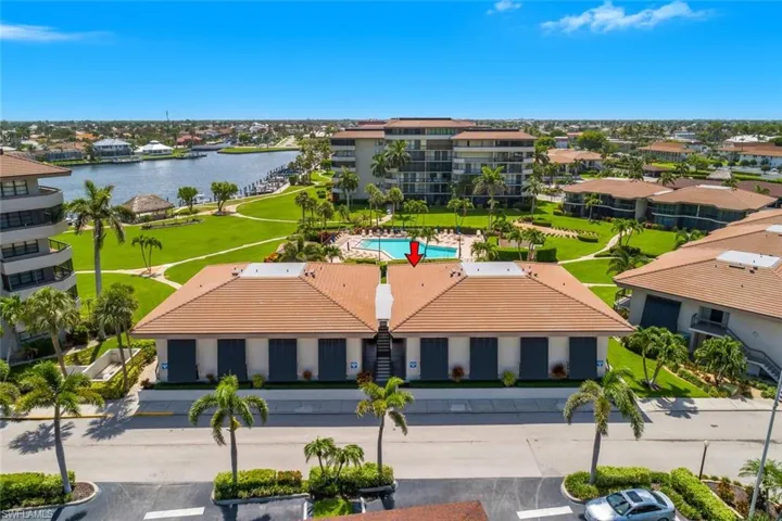 Aerial view of residential area featuring a large body of water and a pool area