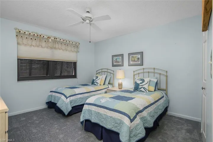 Bedroom featuring carpet floors, a textured ceiling, and ceiling fan
