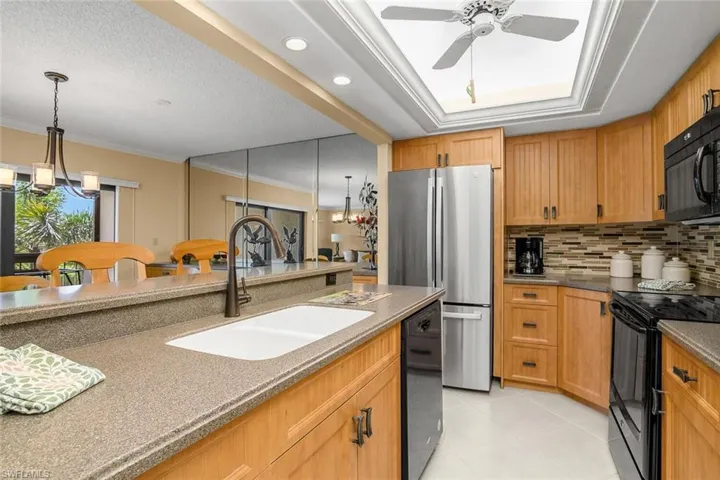 Kitchen featuring black appliances, a ceiling fan, tasteful backsplash, light tile patterned flooring, and ornamental molding