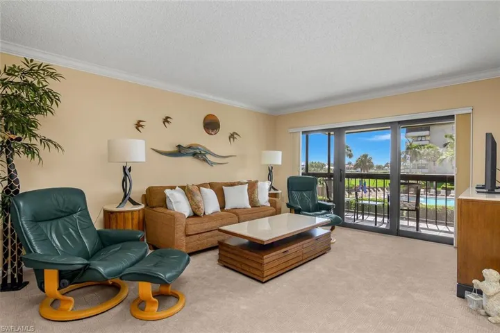 Carpeted living room featuring a textured ceiling and crown molding