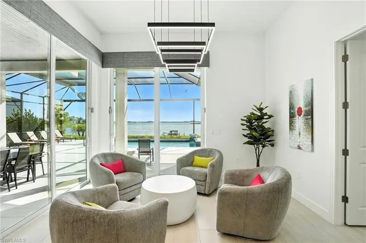 Living area with a sunroom, a water view, and wood finished floors