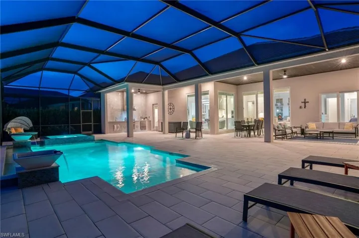 View of pool with ceiling fan, a pool with connected hot tub, a lanai, an outdoor living space, and a sunroom