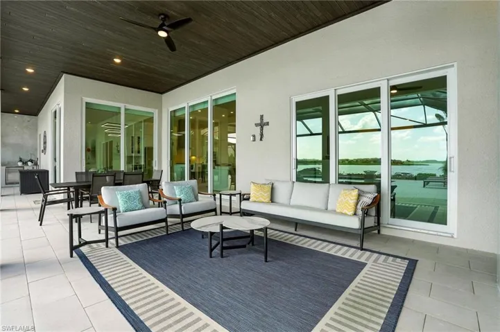 View of patio with an outdoor hangout area, ceiling fan, and a water view