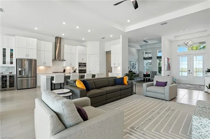 Living room featuring french doors, recessed lighting, wine cooler, a ceiling fan, and light tile patterned floors