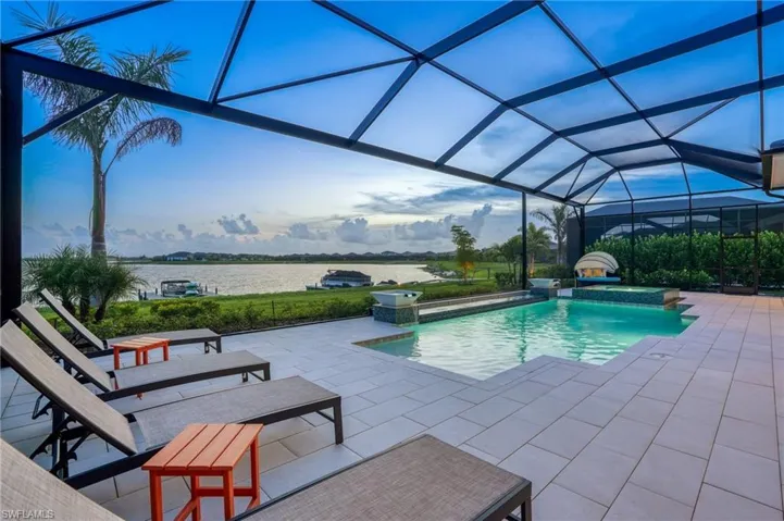 Outdoor pool featuring a lanai, a sunroom, a patio area, a jacuzzi, and a water view