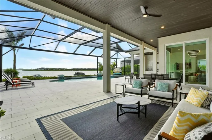 View of patio featuring a sunroom, glass enclosure, a ceiling fan, an outdoor pool, and outdoor lounge area