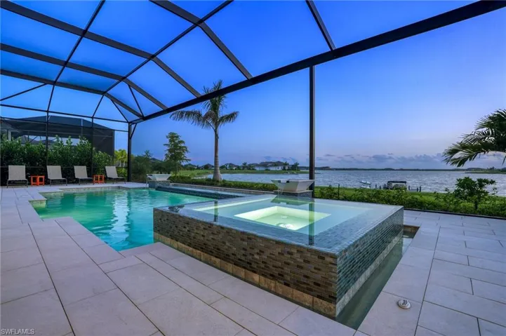 View of swimming pool with a water view, a patio, a sunroom, and glass enclosure
