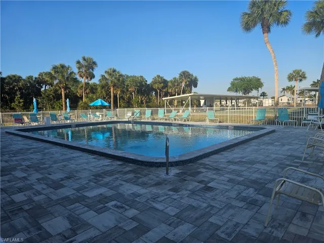Pool with a patio area and fence