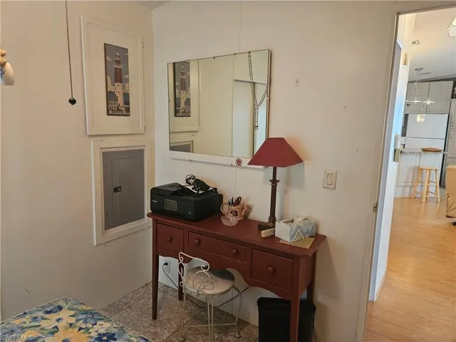 Bedroom with electric panel and wood finished floors
