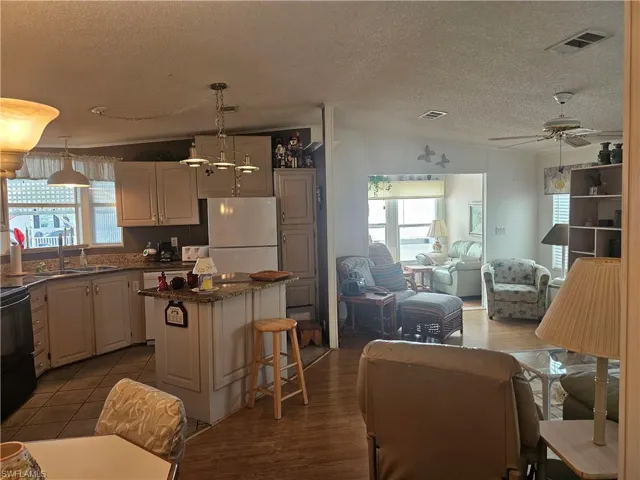 Kitchen with visible vents, a center island, freestanding refrigerator, and plenty of natural light