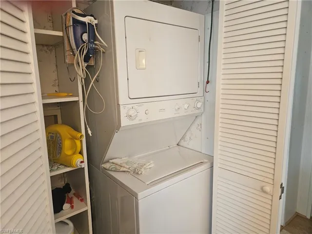 Washroom with stacked washer / dryer and laundry area