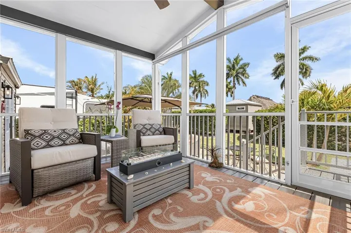 Sunroom featuring healthy amount of natural light, a ceiling fan, and vaulted ceiling