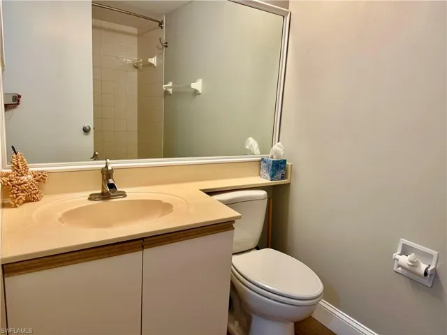 Guest Full bath with toilet, vanity, and tiled shower