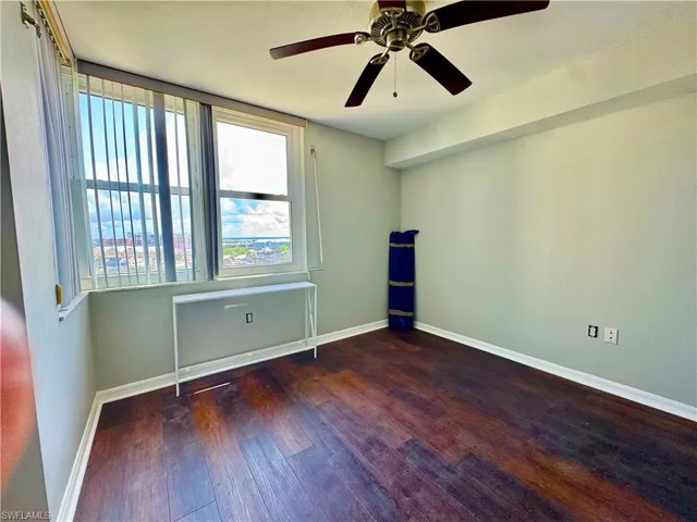 Guest Bedroom featuring wood finished floors, baseboards, and a ceiling fan