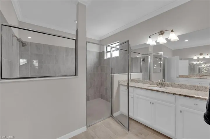 Bathroom with vanity, a shower stall, ornamental molding, and recessed lighting
