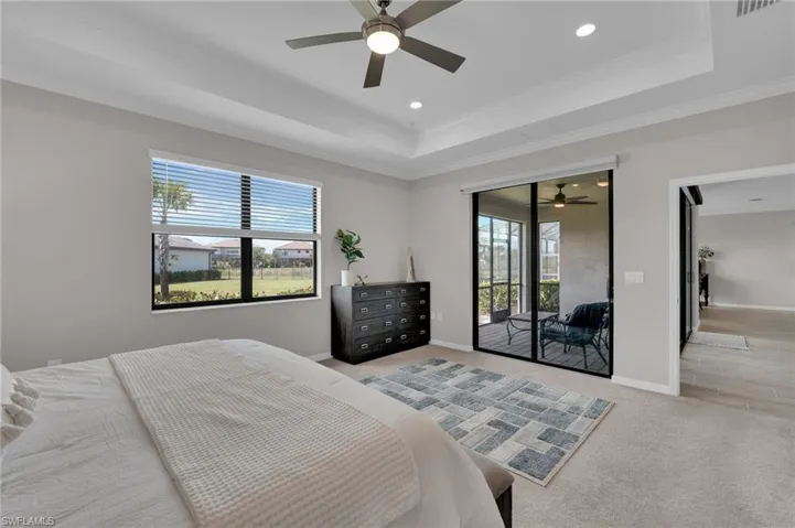 Bedroom with a raised ceiling, carpet, crown molding, access to outside, and ceiling fan