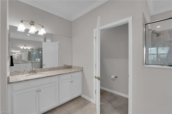Full bathroom with ornamental molding, a stall shower, and vanity
