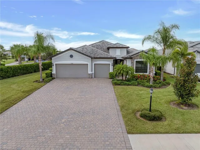 View of front of house with stone siding, an attached garage, stucco siding, decorative driveway, and a front yard