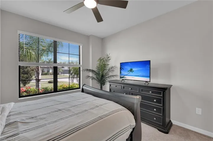 Bedroom featuring light carpet and a ceiling fan