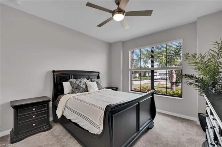Bedroom with light carpet and a ceiling fan