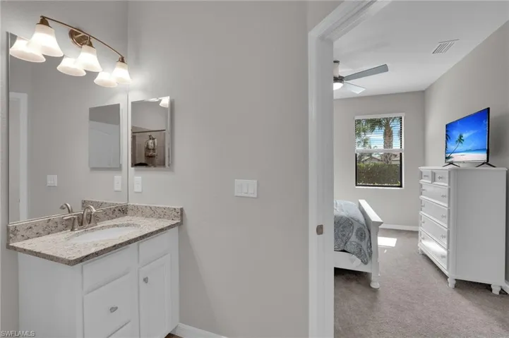 Bathroom featuring vanity, connected bathroom, and a ceiling fan