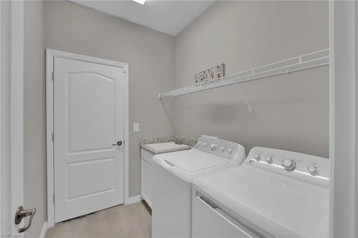 Laundry room featuring washing machine and clothes dryer and light wood-style flooring