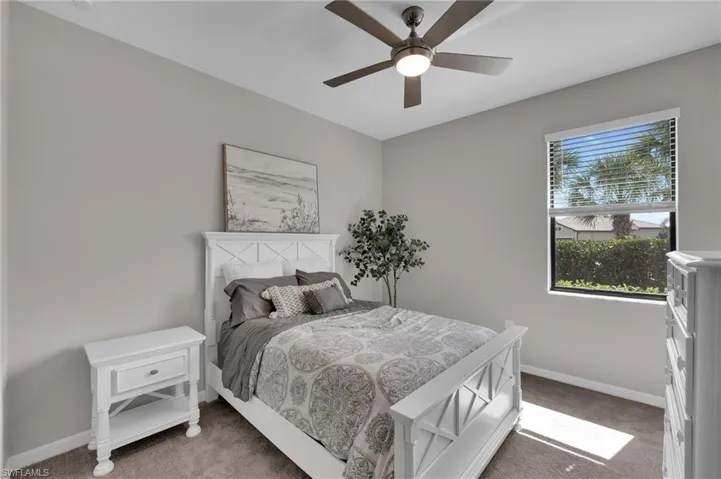 Carpeted bedroom featuring baseboards and ceiling fan