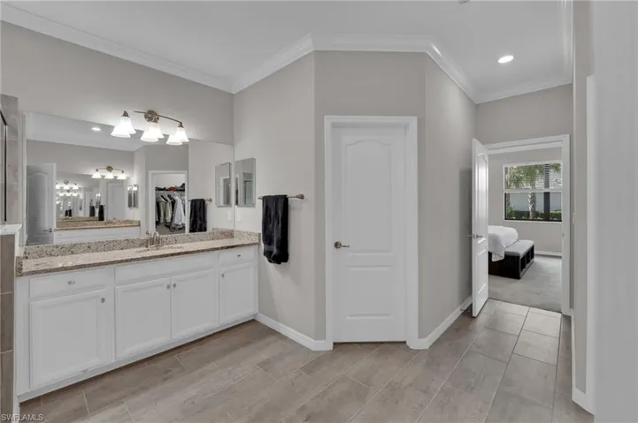 Bathroom featuring crown molding, vanity, a chandelier, and recessed lighting