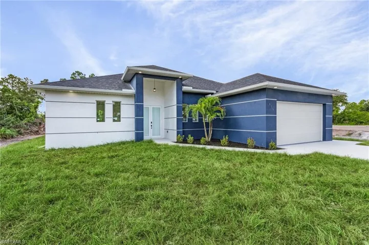 View of front facade with a garage and a front yard