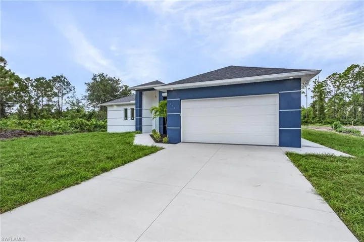 View of front of property featuring a front yard and a garage