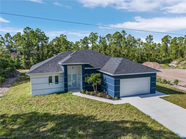 Ranch-style home with a garage and a front lawn