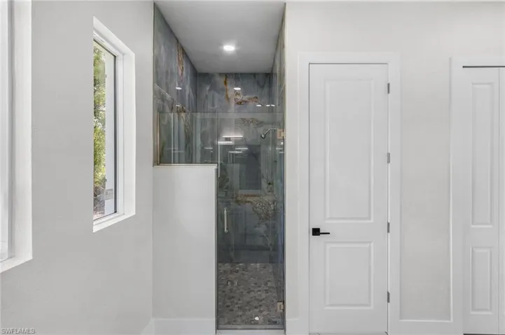 Bathroom with a wealth of natural light and a shower with shower door