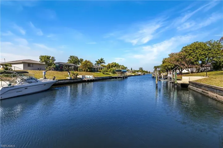 Water view featuring a boat dock and nearby suburban area