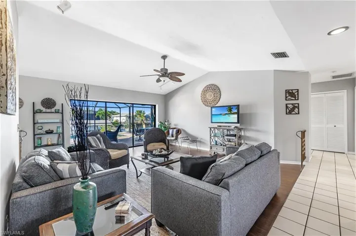Living area featuring wood finished floors, lofted ceiling, and a ceiling fan
