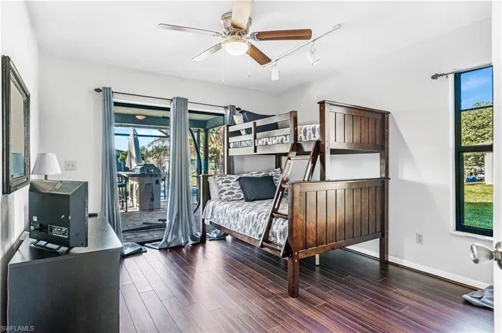 Bedroom featuring dark wood finished floors, access to outside, a ceiling fan, and track lighting
