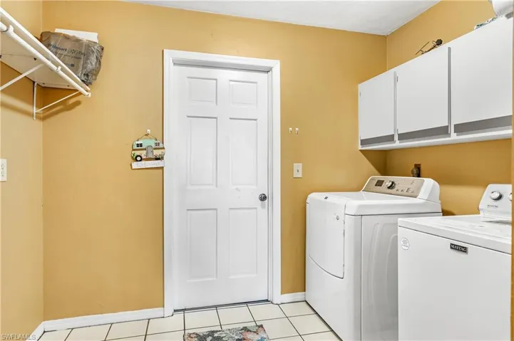 Laundry room featuring independent washer and dryer and light tile patterned floors