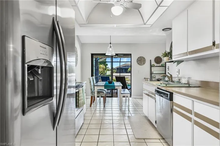 Kitchen featuring white cabinetry, stainless steel appliances, light countertops, light tile patterned floors, and a ceiling fan