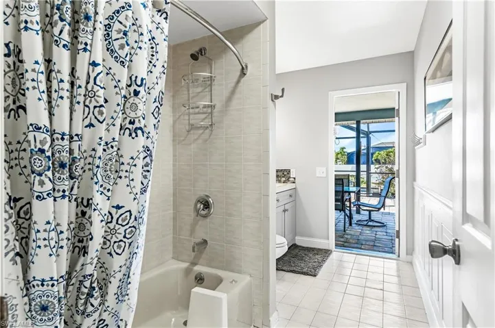 Full bath with shower / bath combination with curtain, vanity, and light tile patterned flooring