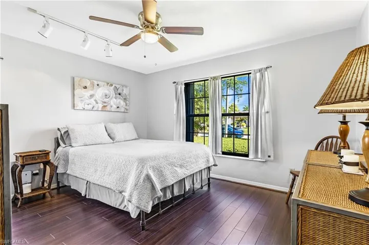 Bedroom featuring track lighting, ceiling fan, and dark wood finished floors