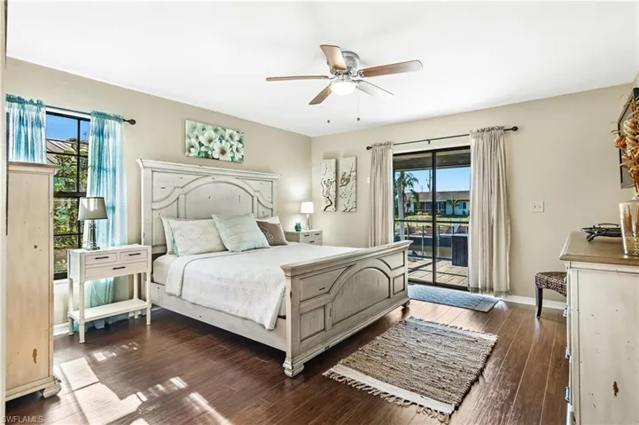 Bedroom featuring dark wood-style flooring, a ceiling fan, and access to outside