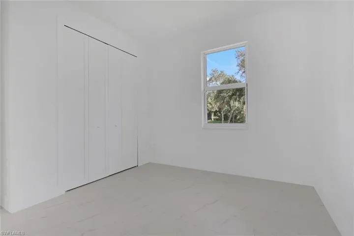 Guest bedroom 2 with light marble finish flooring and a closet