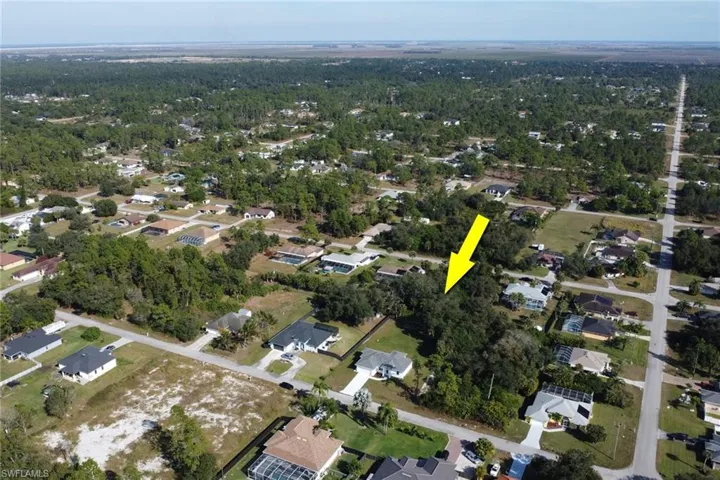 Aerial view of property and surrounding area with nearby suburban area