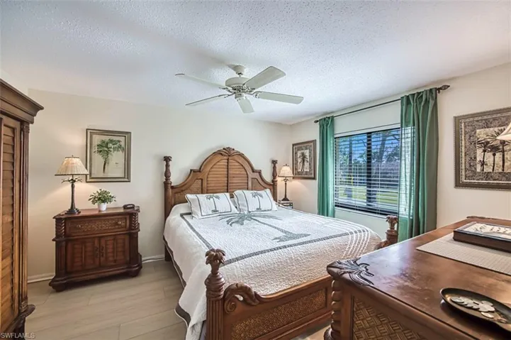Bedroom featuring light hardwood / wood-style floors, a textured ceiling, and ceiling fan