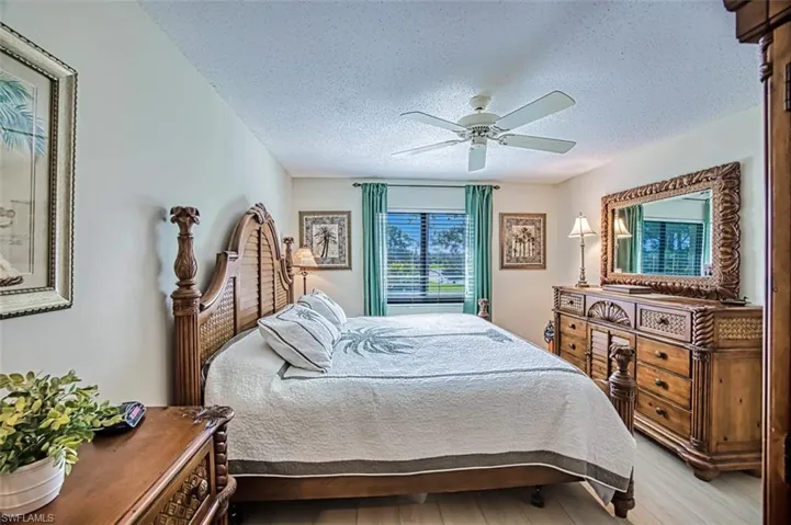 Bedroom featuring a textured ceiling, light hardwood / wood-style flooring, and ceiling fan