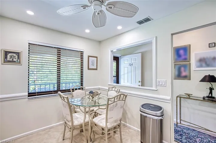 Tiled dining area with ceiling fan and plenty of natural light