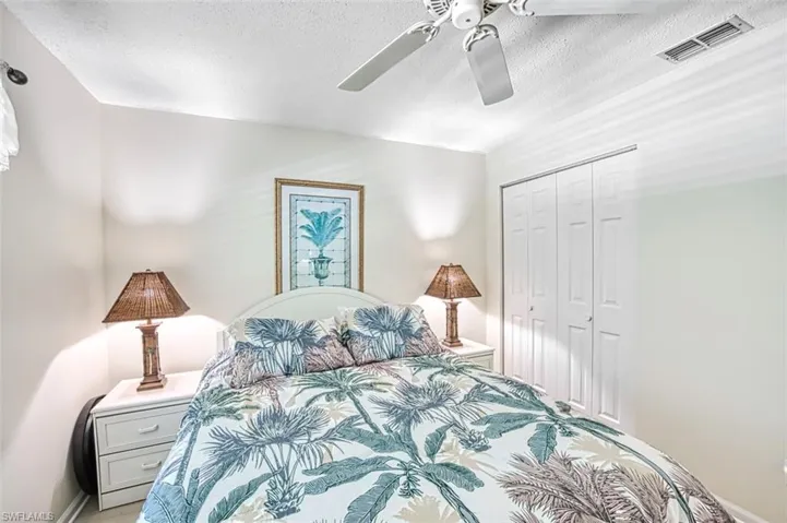 Bedroom with a closet, a textured ceiling, and ceiling fan