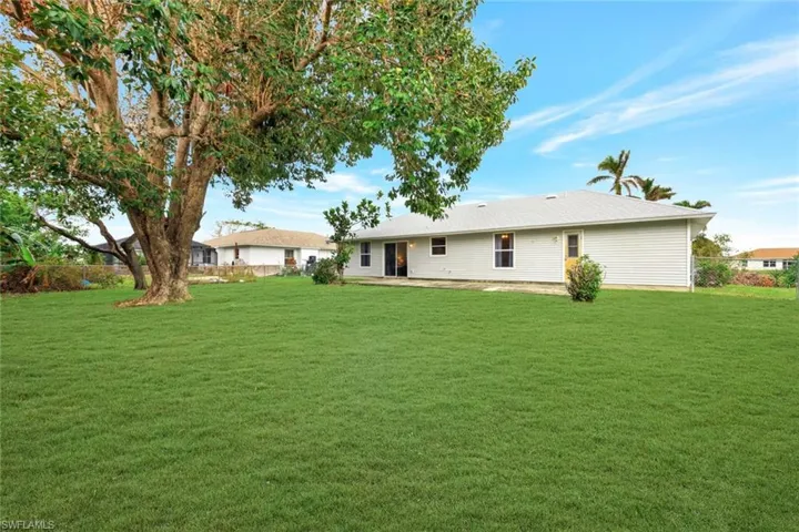 Rear view of home highlights large fenced-in backyard