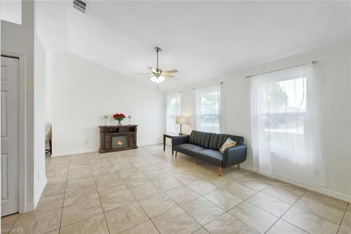 Tiled living room with vaulted ceiling brings lots of natural light.